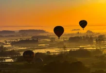Onda de calor em Santa Catarina mantém temperaturas acima de 32°C no fim de semana Balões coloridos sobrevoando a paisagem sob céu limpo e ensolarado, ilustrando o calor intenso e a onda de calor em Santa Catarina.