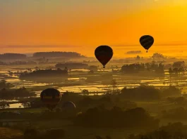 Balões coloridos sobrevoando a paisagem sob céu limpo e ensolarado, ilustrando o calor intenso e a onda de calor em Santa Catarina.
