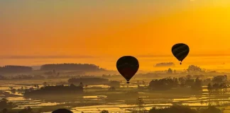 Balões coloridos sobrevoando a paisagem sob céu limpo e ensolarado, ilustrando o calor intenso e a onda de calor em Santa Catarina.