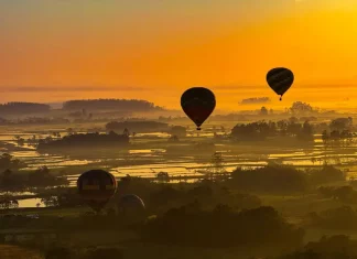 Balões coloridos sobrevoando a paisagem sob céu limpo e ensolarado, ilustrando o calor intenso e a onda de calor em Santa Catarina.