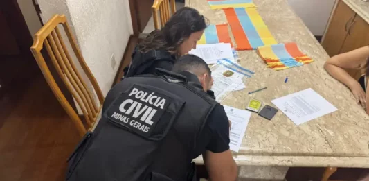 Agentes da Polícia Civil analisam documentos durante busca e apreensão da Operação Dublê contra fraudes e lavagem de dinheiro