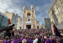 Fiéis participam da Procissão do Senhor dos Passos em frente à Catedral Metropolitana de Florianópolis, com imagens religiosas sendo conduzidas durante a celebração.