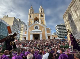 Fiéis participam da Procissão do Senhor dos Passos em frente à Catedral Metropolitana de Florianópolis, com imagens religiosas sendo conduzidas durante a celebração.