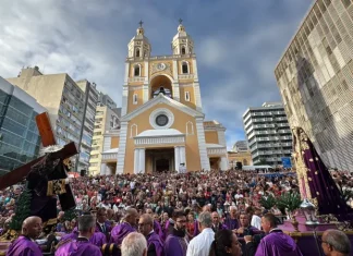 Fiéis participam da Procissão do Senhor dos Passos em frente à Catedral Metropolitana de Florianópolis, com imagens religiosas sendo conduzidas durante a celebração.