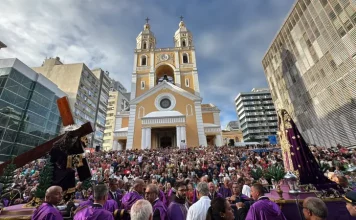 Fiéis participam da Procissão do Senhor dos Passos em frente à Catedral Metropolitana de Florianópolis, com imagens religiosas sendo conduzidas durante a celebração.