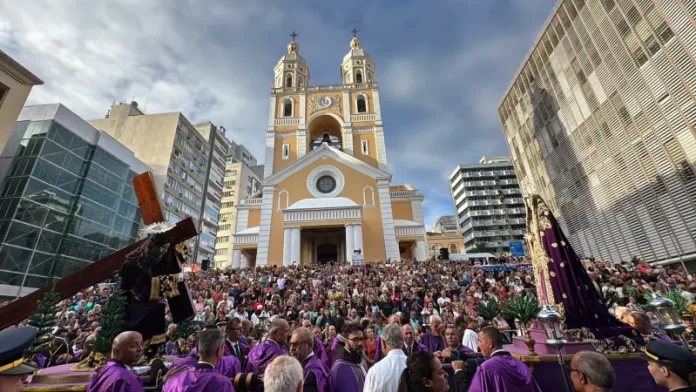 Fiéis participam da Procissão do Senhor dos Passos em frente à Catedral Metropolitana de Florianópolis, com imagens religiosas sendo conduzidas durante a celebração.