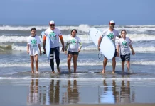 Programa de Incentivo ao Esporte SC amplia acesso e transforma vidas crianças e adolescentes saindo do mar com pranchas de surf durante atividade esportiva, ilustrando a inclusão e o acesso ao esporte promovidos pelo Programa de Incentivo ao Esporte SC