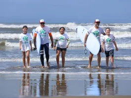 crianças e adolescentes saindo do mar com pranchas de surf durante atividade esportiva, ilustrando a inclusão e o acesso ao esporte promovidos pelo Programa de Incentivo ao Esporte SC