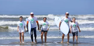 crianças e adolescentes saindo do mar com pranchas de surf durante atividade esportiva, ilustrando a inclusão e o acesso ao esporte promovidos pelo Programa de Incentivo ao Esporte SC