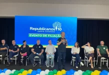 Republicanos SC realiza evento de filiação com mais de 500 pessoas em Palhoça Evento de filiação do Republicanos SC em Palhoça, com o governador Jorginho Mello discursando ao microfone diante de lideranças políticas no palco.