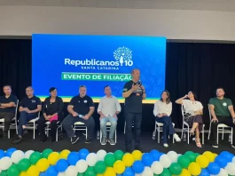 Evento de filiação do Republicanos SC em Palhoça, com o governador Jorginho Mello discursando ao microfone diante de lideranças políticas no palco.
