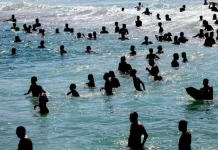 Turistas se refrescando na água durante sol e calor no litoral catarinense