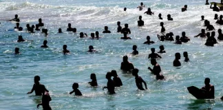 Turistas se refrescando na água durante sol e calor no litoral catarinense