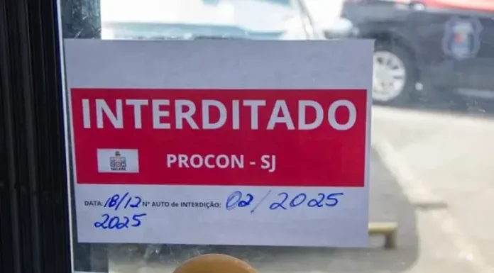 São José aprova lei para suspensão de alvarás de estabelecimentos que vendem produtos ilícitos Placa de ‘interditado pelo Procon de São José’ colada na porta de vidro de um comércio, representando suspensão de alvará em São José.