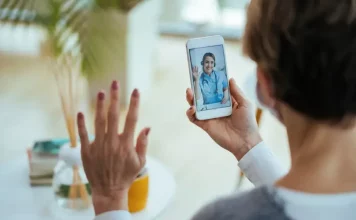 Moradora realiza consulta médica por videochamada no celular, ilustrando o funcionamento do Tele Saúde São José com atendimento digital 24 horas.