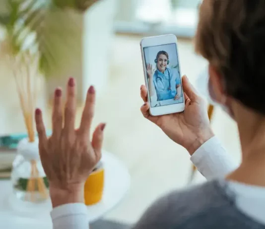 Moradora realiza consulta médica por videochamada no celular, ilustrando o funcionamento do Tele Saúde São José com atendimento digital 24 horas.