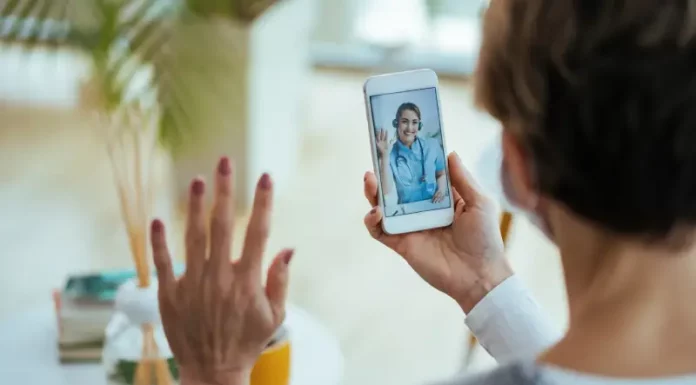 Moradora realiza consulta médica por videochamada no celular, ilustrando o funcionamento do Tele Saúde São José com atendimento digital 24 horas.