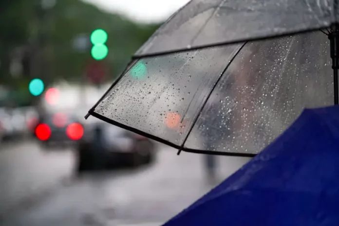temporais Guarda-chuva com gotas de chuva em rua urbana representa a chegada de temporais em Santa Catarina e a mudança no tempo no início da semana