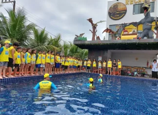 Crianças participam de atividade do Projeto Golfinho SC em piscina, acompanhadas por instrutores, aprendendo práticas de prevenção de afogamentos e segurança na água.