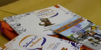 Cadernos e materiais do Programa Defesa Civil na Escola sobre mesa, utilizados para ensinar alunos sobre prevenção de desastres e segurança nas escolas.