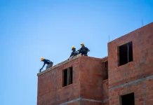 Trabalhadores atuam na construção de unidades habitacionais em Florianópolis, ilustrando o avanço de obras do programa Floripa Para Todos.