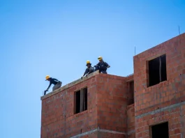 Trabalhadores atuam na construção de unidades habitacionais em Florianópolis, ilustrando o avanço de obras do programa Floripa Para Todos.