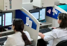 Profissionais de saúde utilizam computadores em central de teleatendimento, ilustrando o uso da saúde digital e da telemedicina no suporte remoto a pacientes em São José.