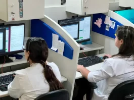 Profissionais de saúde utilizam computadores em central de teleatendimento, ilustrando o uso da saúde digital e da telemedicina no suporte remoto a pacientes em São José.