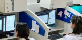 Profissionais de saúde utilizam computadores em central de teleatendimento, ilustrando o uso da saúde digital e da telemedicina no suporte remoto a pacientes em São José.