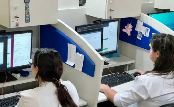 Profissionais de saúde utilizam computadores em central de teleatendimento, ilustrando o uso da saúde digital e da telemedicina no suporte remoto a pacientes em São José.