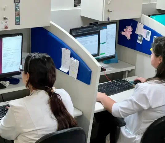 Profissionais de saúde utilizam computadores em central de teleatendimento, ilustrando o uso da saúde digital e da telemedicina no suporte remoto a pacientes em São José.