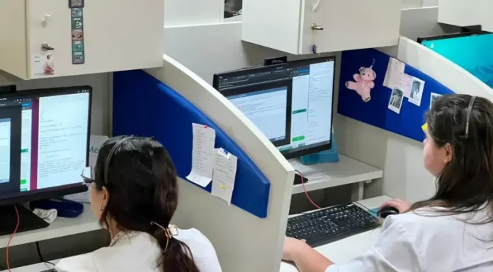 Profissionais de saúde utilizam computadores em central de teleatendimento, ilustrando o uso da saúde digital e da telemedicina no suporte remoto a pacientes em São José.