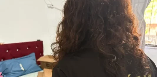 PF e Anvisa combatem comércio ilegal de medicamentos para emagrecimento Policial federal durante ação contra comércio ilegal de medicamentos, com remédios apreendidos sobre cama em residência.