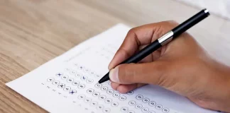 Mão preenchendo gabarito de prova, simulando participação no concurso da InvestSC.