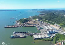 Vista aérea de complexo portuário em Santa Catarina, com navios atracados, armazéns e área de carga e descarga, ilustrando a atividade da Economia do Mar e sua importância para a logística e geração de empregos no estado.