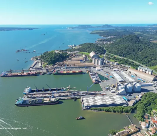 Vista aérea de complexo portuário em Santa Catarina, com navios atracados, armazéns e área de carga e descarga, ilustrando a atividade da Economia do Mar e sua importância para a logística e geração de empregos no estado.