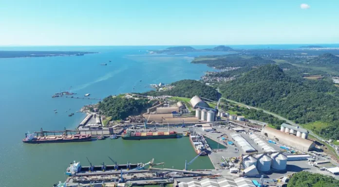 Vista aérea de complexo portuário em Santa Catarina, com navios atracados, armazéns e área de carga e descarga, ilustrando a atividade da Economia do Mar e sua importância para a logística e geração de empregos no estado.