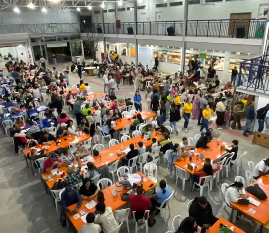 Público participa da festa do Educandário Santa Catarina em São José, com mesas cheias, bingo e atividades comunitárias em espaço coberto da instituição.