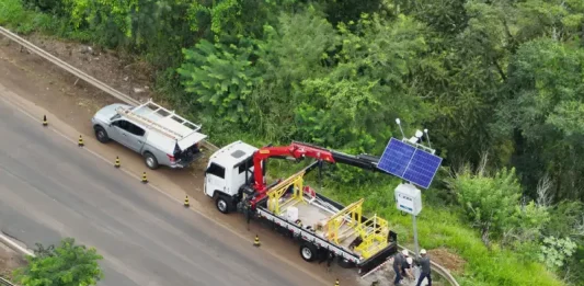 Instalação de estações meteorológicas e hidrológicas às margens de rodovia, com uso de caminhão guindaste e painel solar, para monitoramento do clima e prevenção de desastres em tempo real.