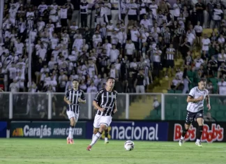 Torcedores do Figueirense acompanham a partida entre Figueirense e Botafogo-SP, no estádio Orlando Scarpelli, enquanto jogadores disputam a bola em campo, ilustrando o clima do jogo e a presença da torcida no futebol catarinense.