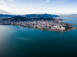 Vista aérea de Florianópolis, mostrando a área urbana cercada pelo mar, utilizada para ilustrar a cidade que aderiu à Declaração de Belém e adotou medidas de compras públicas sustentáveis.