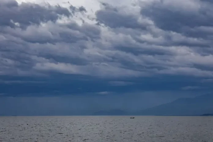 Céu carregado com nuvens escuras sobre o mar, indicando a aproximação de frentes frias e a possibilidade de chuva e temporais no litoral de Santa Catarina.