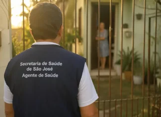 Imagem gerada por IA mostra um homem com colete de agente de saúde da Secretaria de São José em frente a uma residência, ilustrando a ação de golpistas que se passam por profissionais para aplicar fraudes.