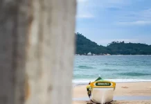 Barco de pesca artesanal na faixa de areia, com o mar ao fundo, em Florianópolis, ilustrando o cenário da safra da tainha e a importância da atividade pesqueira no litoral.