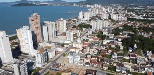 Vista aérea de Balneário Piçarras mostra área urbana com prédios e a orla, ilustrando o crescimento da cidade e o contexto de desenvolvimento abordado pelo programa SC Cidades do Futuro.
