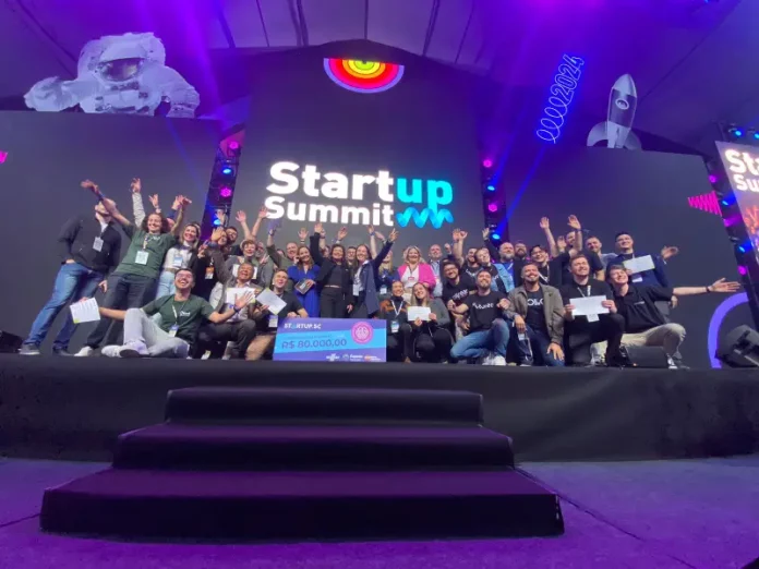 Grupo de participantes celebra no palco do Startup Summit o anúncio do Programa Acelera Startup SC, que investirá R$ 1,6 milhão em startups catarinenses.