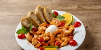 Prato do Festival Brasil Sabor com camarões salteados, burrata, tomates-cereja, pão e fatias de limão, destacando a gastronomia catarinense.