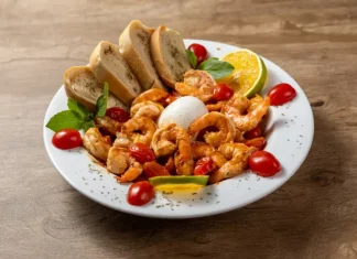 Prato do Festival Brasil Sabor com camarões salteados, burrata, tomates-cereja, pão e fatias de limão, destacando a gastronomia catarinense.
