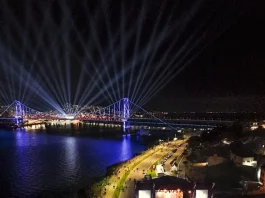 Centenário da Ponte Hercílio Luz reúne cerca de 100 mil pessoas no fim de semana Vista aérea mostra o público reunido na Beira-Mar Continental durante as comemorações do centenário da Ponte Hercílio Luz, em Florianópolis, com palco de shows, iluminação especial e feixes de luz sobre a ponte durante evento noturno.