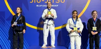 Atletas de jiu-jitsu posam no pódio durante o Campeonato Mundial da IBJJF, na Califórnia. Ao centro, Ester Boing aparece no lugar mais alto do pódio com a medalha de ouro, representando a conquista do título mundial da categoria faixa-azul. A imagem destaca o resultado histórico da atleta de São José no cenário internacional da modalidade.